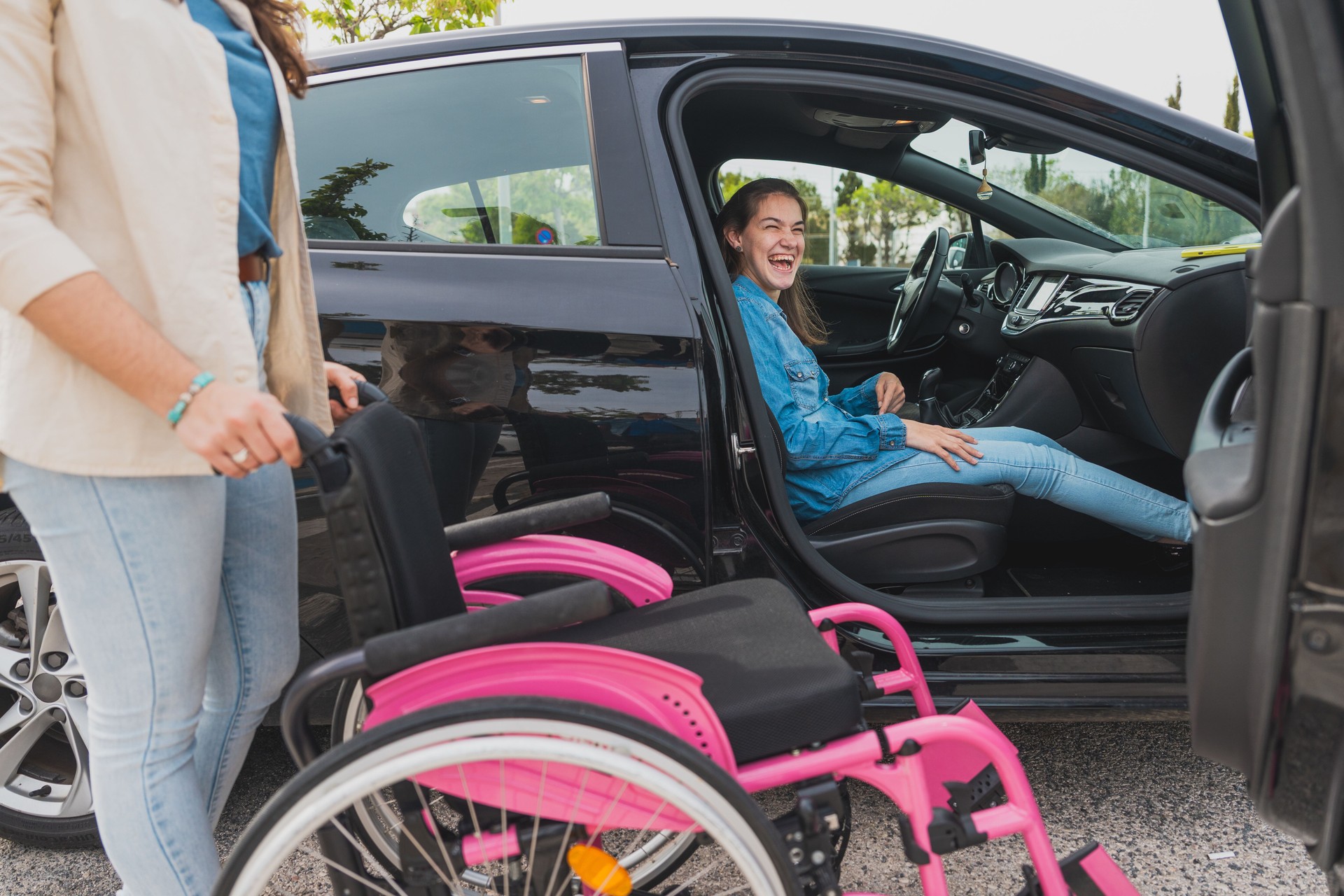 Young woman with cerebral palsy prepares to exit car with assistant’s help